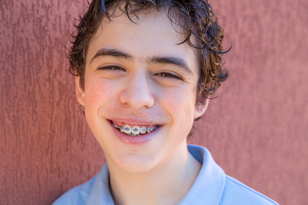 Nuori poika hymyilee hammasraudoilla
 - Valokuva, kuva