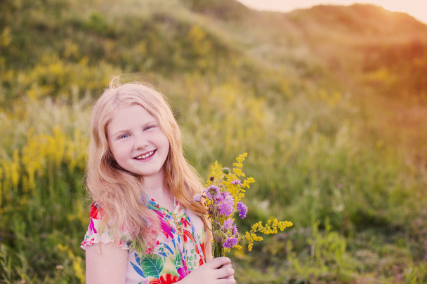 Szczęśliwa dziewczyna blond na łąki przy zachodzie słońca - Zdjęcie, obraz