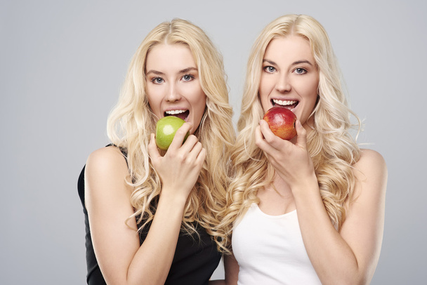 Blondynka bliźnięta jedzenia jabłek - Zdjęcie, obraz