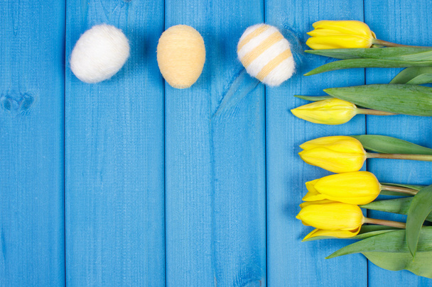 Bouquet of fresh tulips and Easter eggs wrapped woolen string, Easter decoration, copy space for text - Foto, imagen