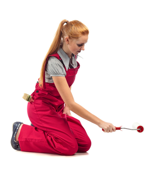 Young happy woman in red jumpsuit with painting tools  - Photo, Image