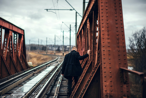 Man with beard walking on the railway - Foto, afbeelding