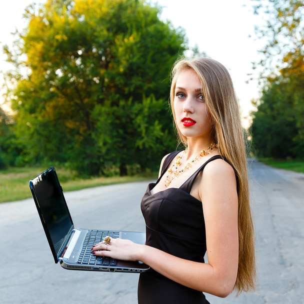 jeune belle femme d'affaires tenant un ordinateur portable sur la route
 - Photo, image