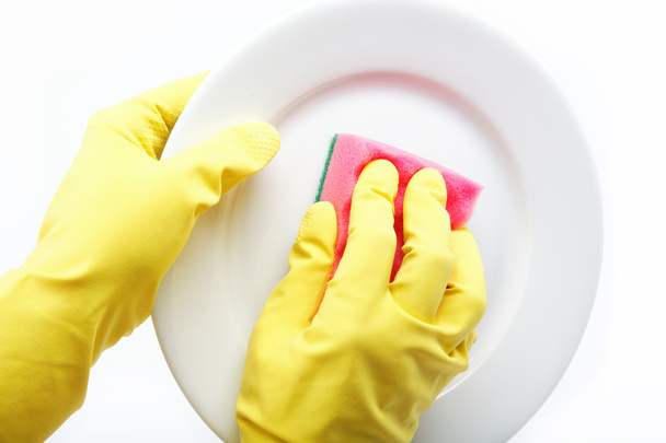 Hands in rubber gloves can sponge the plate on a white backgroun - Photo, image