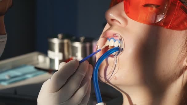 Wybielanie zębów zbliżenie w zwolnionym tempie - Materiał filmowy, wideo