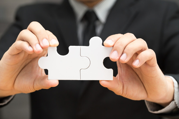Businessmen holding two jigsaw to connect - Photo, Image