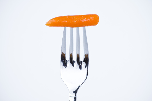 Diet, carrot bite in a fork - Foto, afbeelding