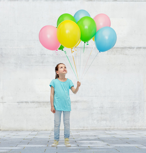 girl looking up with bunch of helium balloons - Photo, image