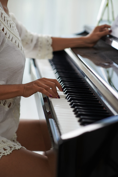 manos femeninas tocando teclas de piano
 - Foto, imagen