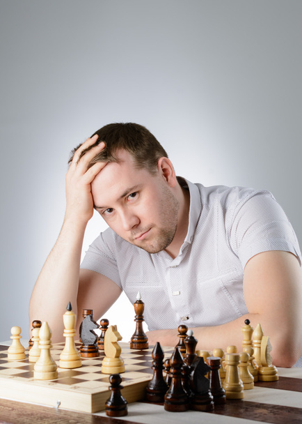 El hombre está pensando en una partida de ajedrez.
 - Foto, imagen