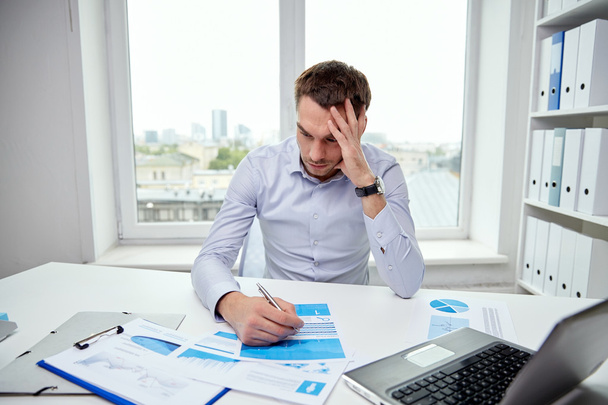 stressed businessman with papers in office - Photo, image