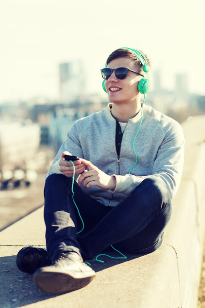 happy young man in headphones with smartphone - Foto, Bild