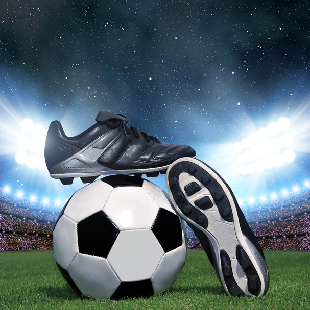 Pelota de fútbol y zapatos en hierba
 - Foto, imagen