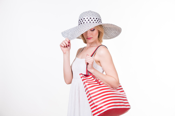 Jolie femme au chapeau élégant tenant sac rayé blanc rouge. Femme de mode souriante. Isolé
 - Photo, image