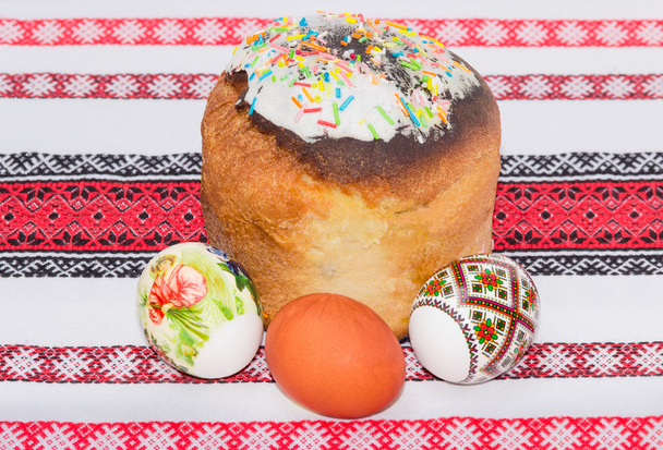 Easter cake and several different Easter eggs on a tablecloth - Photo, Image