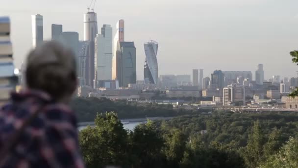 Girl looks at the city. panorama of the city - Footage, Video