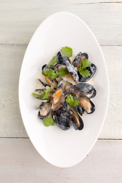 Mussels in a plate on white wooden background - Photo, Image