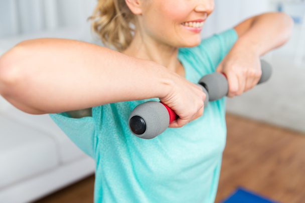 close up of woman exercising with dumbbell at home - Foto, Bild