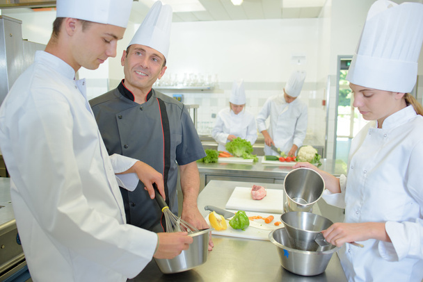 Chef supervising trainees and chef - Foto, afbeelding