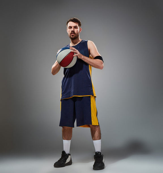 Full length portrait of a basketball player posing with ball - Zdjęcie, obraz