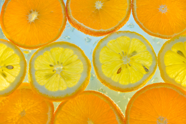 Rebanadas de fruta en agua con burbujas
 - Foto, Imagen