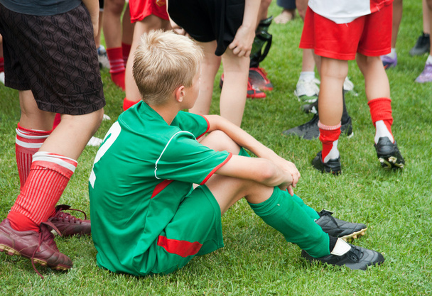 Boy sitting tired after the game - 写真・画像