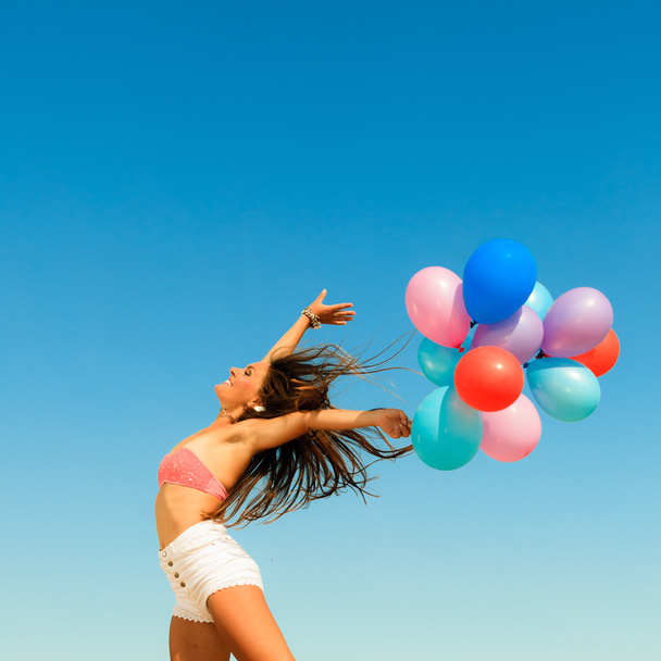 Frau springt mit bunten Luftballons - Foto, Bild