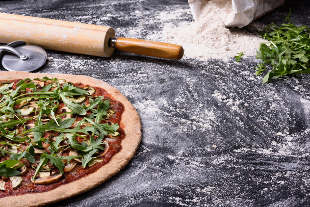 Italian pizza with arugula and mushrooms on wooden table. Copy space - Photo, Image