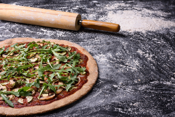 Vegetarian pizza with arugula and mushrooms on rustic background. Copy space, top view. - Photo, Image