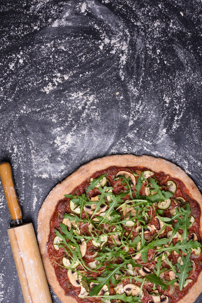 Italian pizza with mushrooms, cheese and arugula salad on wooden table. Top view, copy space. - Foto, imagen