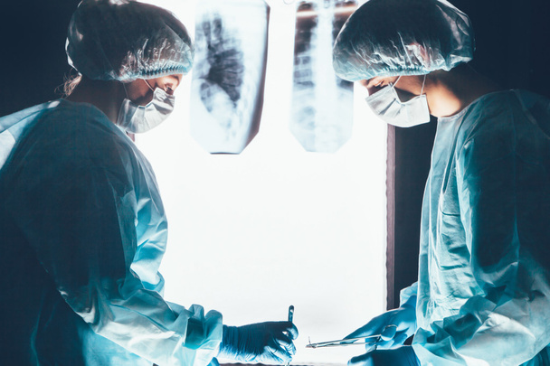 Δύο χειρουργοί εργάζονται και συγκέντρωση στο χειρουργικό τραπέζι - Φωτογραφία, εικόνα
