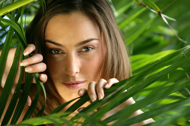 Woman hiding behind a plant - Photo, Image