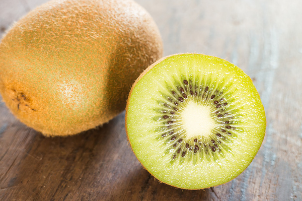 Kiwi fruit on brown wooden background - 写真・画像