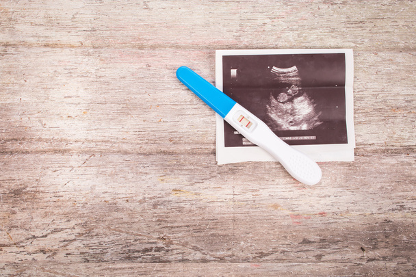 УЗИ с тестом на беременность на деревянном фоне
 - Фото, изображение