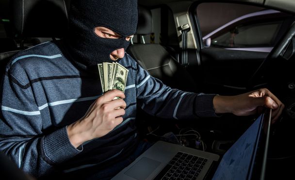 Hacker with a laptop inside a car - Photo, Image