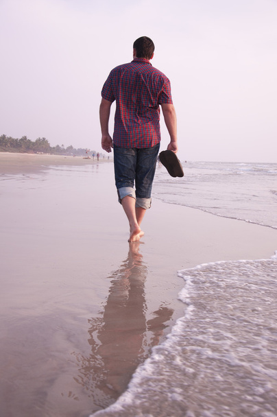 man lopen langs de zee kosten - Foto, afbeelding