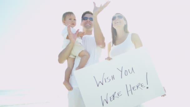 Οικογένεια στην παραλία κρατώντας το μήνυμα του σκάφους - Πλάνα, βίντεο