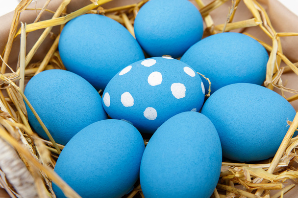 Blue easter eggs in a basket on a white wooden table - Foto, imagen