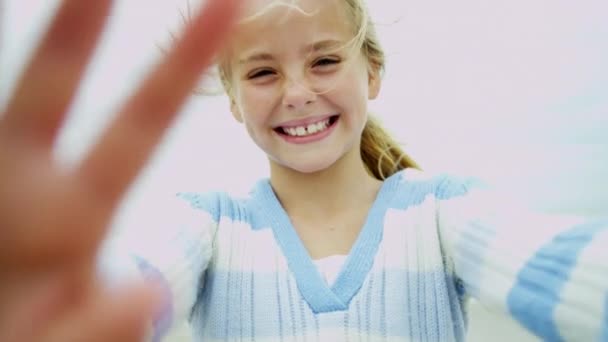 Tyttö rannalla hymyilee kameralle
 - Materiaali, video