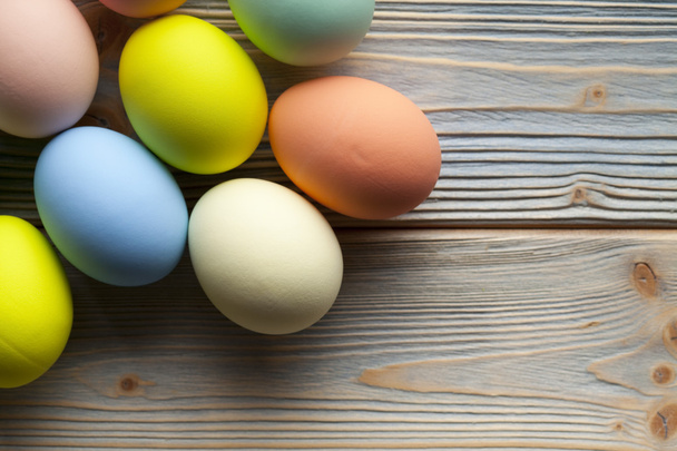 Colored Easter eggs on wooden planks - Фото, изображение