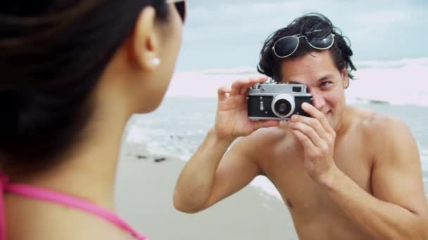 Coppia sulla spiaggia con macchina fotografica
 - Filmati, video