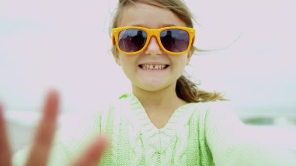 Menina na praia sorrindo para a câmera
 - Filmagem, Vídeo