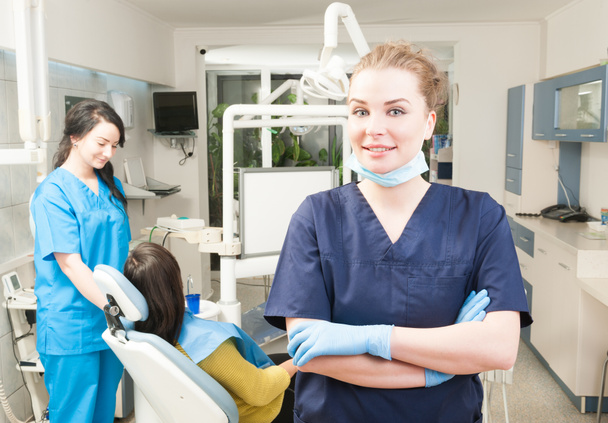 Красивый улыбающийся врач смотрит в камеру в стоматологической клинике
 - Фото, изображение