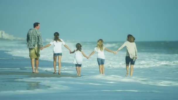 Padres con hijas caminando en la playa
 - Imágenes, Vídeo
