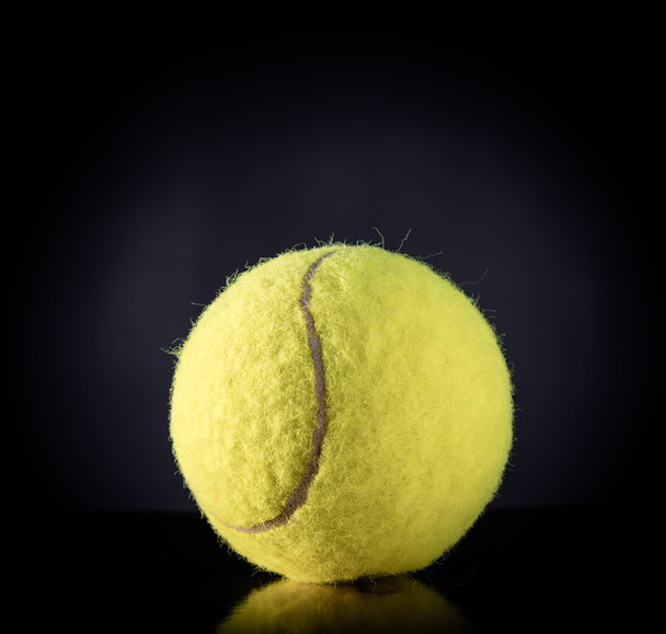 тенісний м'яч ізольований на чорному з драматичним освітленням
 - Фото, зображення