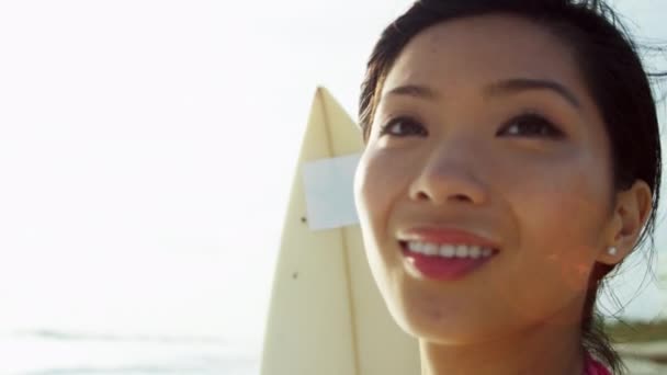 Chica sosteniendo tabla de surf en la playa
 - Metraje, vídeo