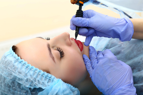 Cosmetologist making permanent makeup on woman's face - Foto, immagini