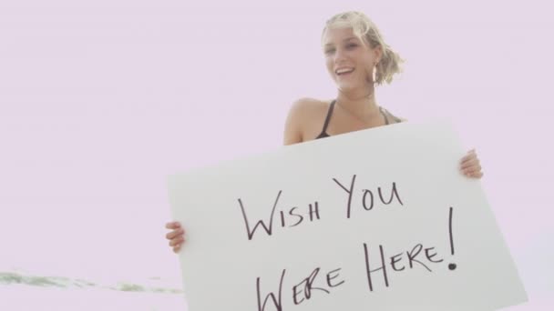 Chica en bikini sosteniendo tablero de mensajes
 - Metraje, vídeo