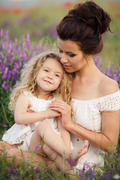 Happy mother and daughter in a field of blooming lavender - Фото, зображення