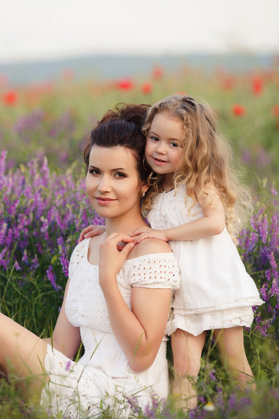 Happy mother and daughter in a field of blooming lavender - Photo, image